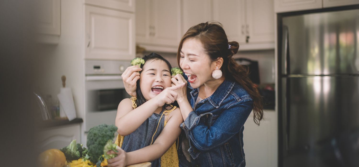 mum and daughter cooking in kitchen and having fun