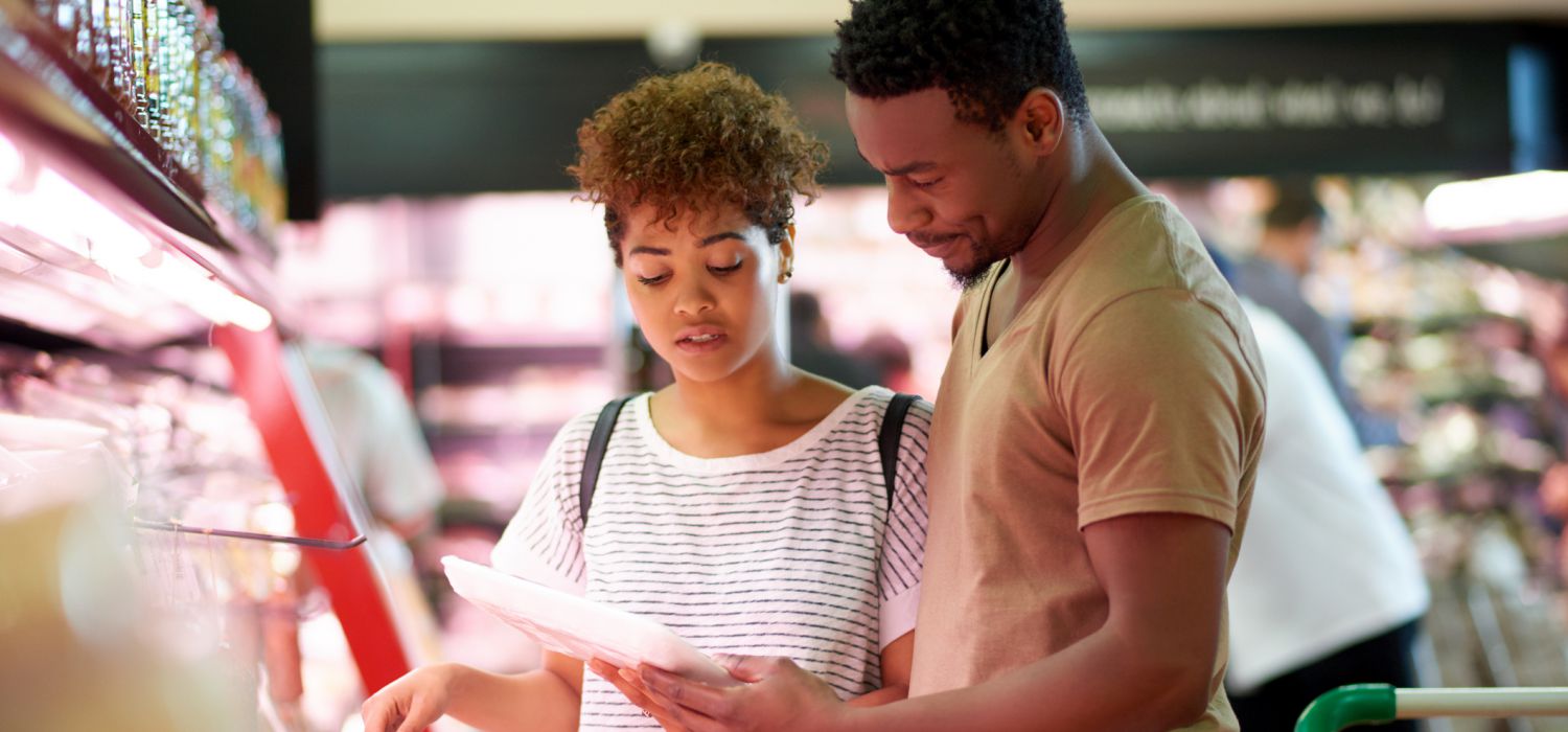 lady and man looking at shopping list in supermarket