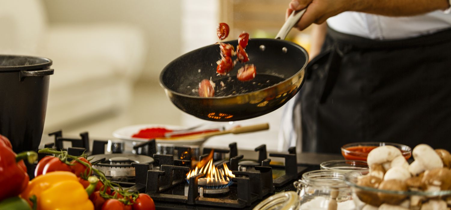 cooking at home and tossing food in frying pan